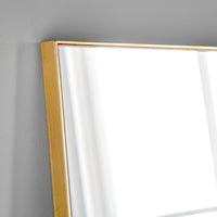 Gold-framed mirror on a gray wall