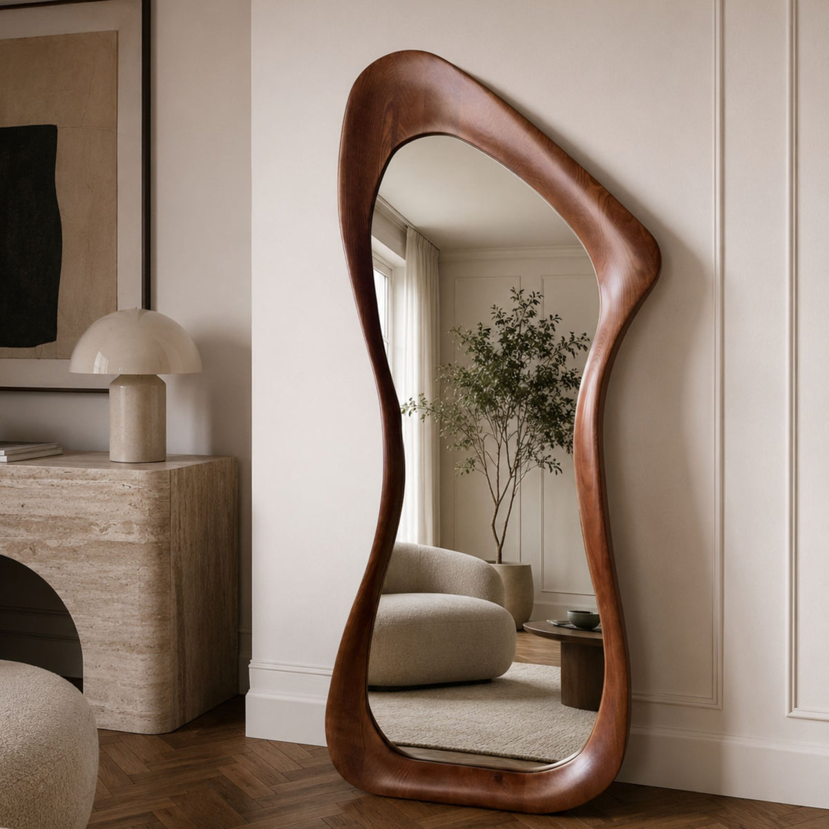 An organic-shaped full-length floor mirror with a rich, wavy brown wooden frame, styled in a warm, modern living room setting.