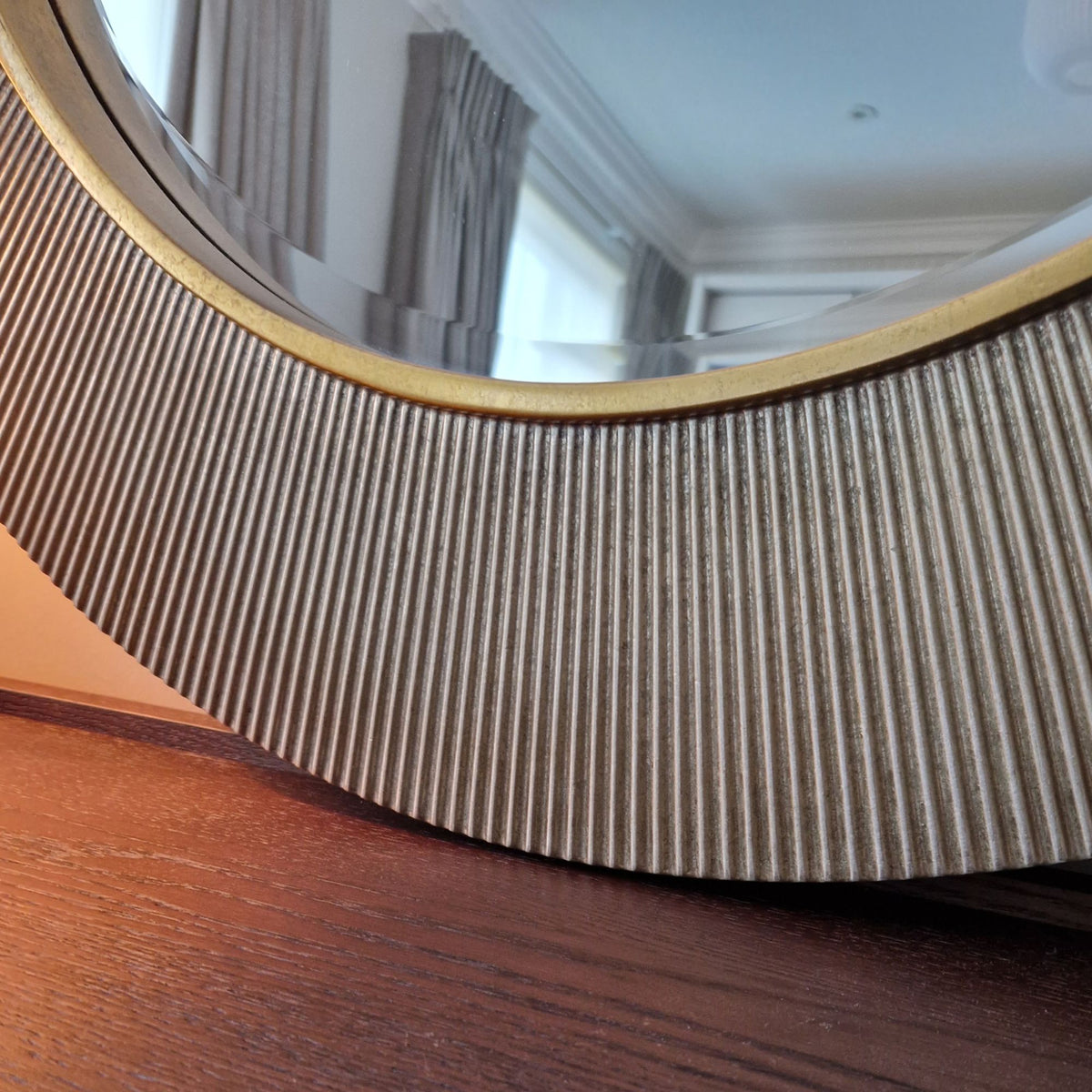 Round mirror with a wooden frame on a wooden surface
