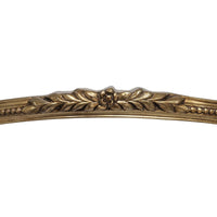 Decorative gold metal strip with leaf and floral patterns on a white background