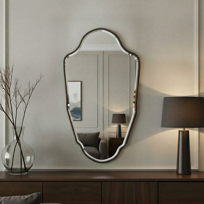 Decorative mirror on a wall with a lamp and vase in a room setting