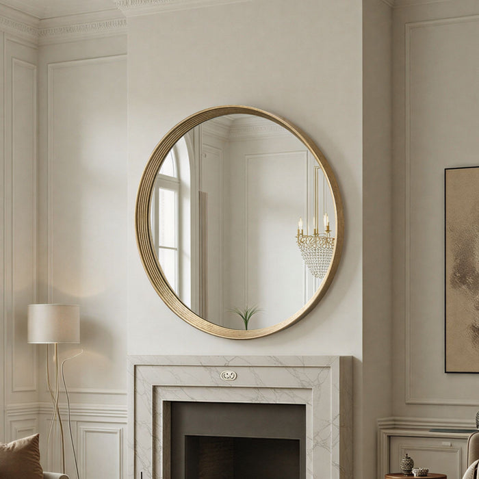 Round gold-framed mirror on a wall above a fireplace in a stylish room.